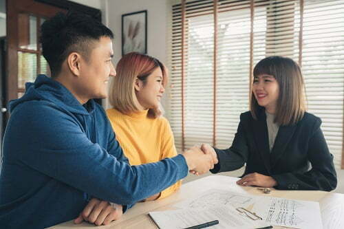Happy young Asian couple and realtor agent. Cheerful young man s